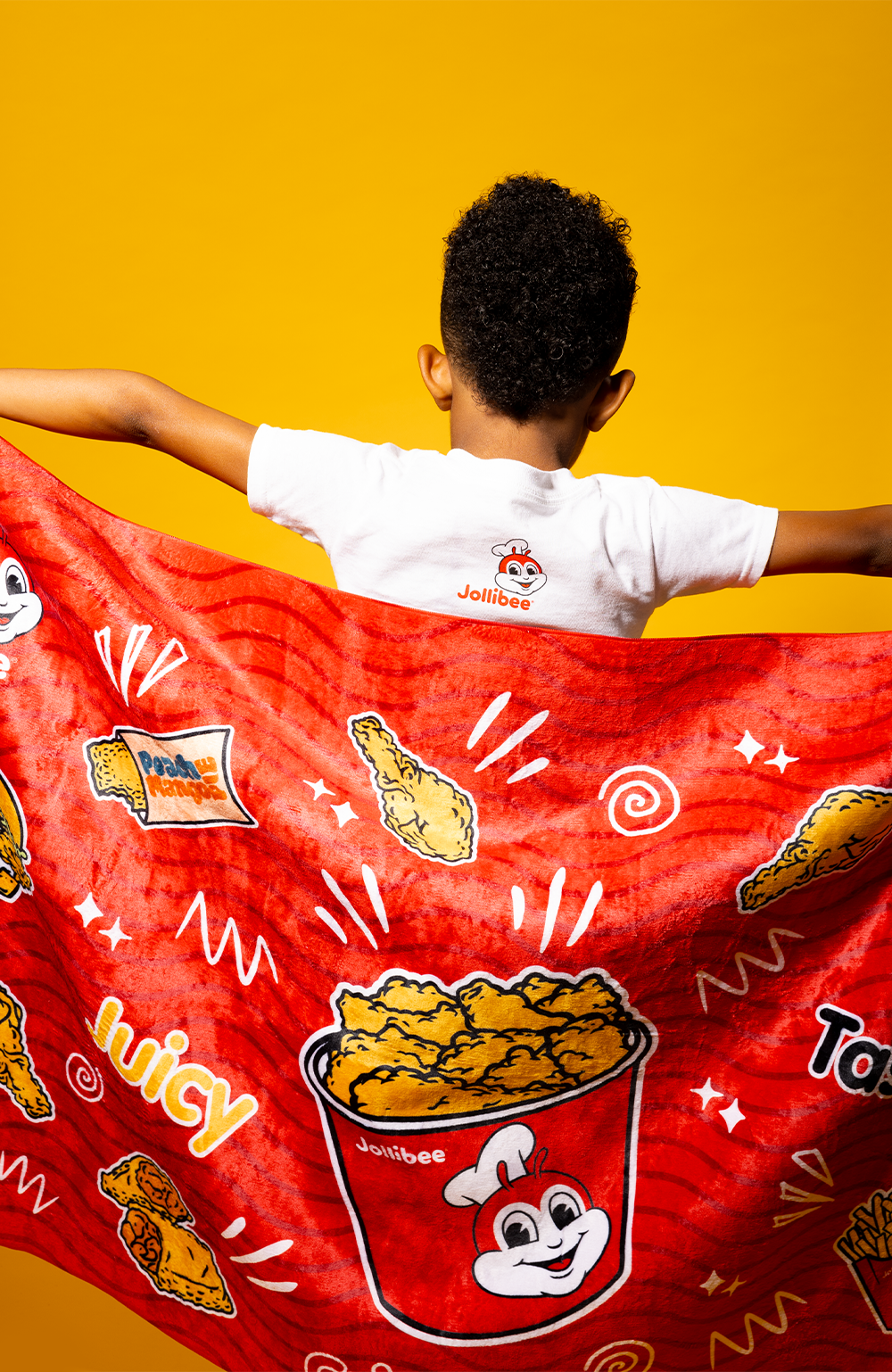 boy holding the Jollibee beach towel behind him
